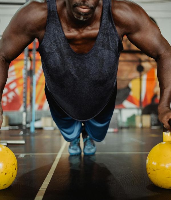 A man holding a kettlebell with a look of intense focus and determination.